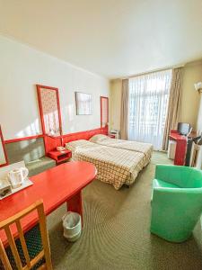 ein Hotelzimmer mit einem Schlafzimmer mit einem Bett und einem Tisch in der Unterkunft Hotel Le Dome in Brüssel