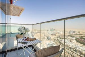 a balcony with a table and chairs and a view of a city at Frank Porter - Miraclz by Danube in Dubai