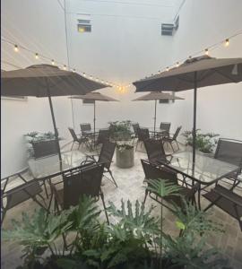 an empty patio with tables and chairs and umbrellas at Hotel California Center in Medellín