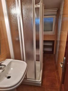 ein Bad mit einer Dusche und einem Waschbecken in der Unterkunft Piso Don Ramón in Razo