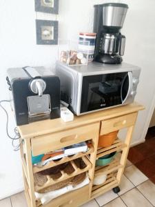 a microwave sitting on top of a table with a coffee maker at Appartement charmant à Cabourg avec piscine partagée (24 m²) in Cabourg
