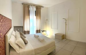 una camera da letto con letto, lenzuola e cuscini bianchi di Il Tenore B&B a Verona