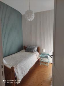 um quarto com uma cama e uma mesa lateral em Maison La Baule vieux guézy Plage et commerces à pieds em La Baule