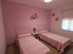 two beds in a bedroom with pink walls at Casa cerca del mar con piscina privada, aire opcional, wifi gratuito, mascotas y playas para perros - ES-184-60 in L'Ametlla de Mar +27 photos