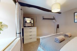 a bedroom with a bed with a dresser and a mirror at The Barn Timberscombe in Timberscombe