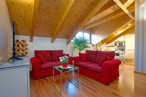 una sala de estar con 2 sofás rojos y una mesa. en Cozy Apartment with view - LAGHI E SENTIERI - 