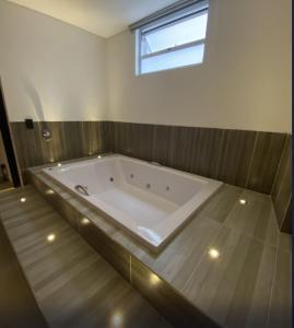 a large bath tub in a bathroom with a window at Hotel California Center in Medellín