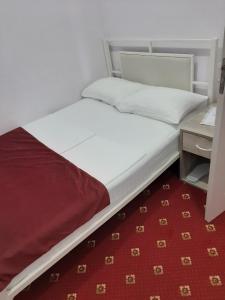 エレバンにあるHotel Erebuni Plazaの赤いカーペット敷きの部屋のベッド1台
