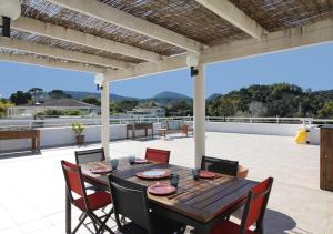 un patio al aire libre con mesa de madera y sillas en Golf Holidays in Mandelieu-la-Napoule, en Mandelieu-la-Napoule