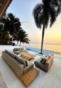 a living room with a couch and chairs and the beach at Villa Teri in Lipa Noi