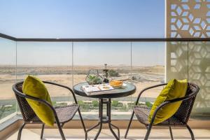 stół i krzesła przed dużym oknem w obiekcie Frank Porter - Majestique Residence 2 w Dubaju