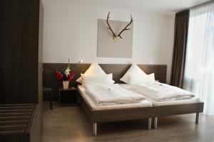 una camera con due letti e un orologio a muro di Hotel Palko a Dingolfing