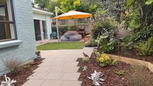 un patio con sombrilla junto a una casa en Studio Wing in Saint Heliers en Auckland
