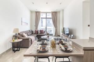 uma sala de estar com uma mesa e um sofá em Frank Porter - Majestique Residence 2 em Dubai
