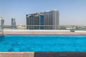 a large blue swimming pool on top of a building at Frank Porter - Oasis Tower 1 in Dubai