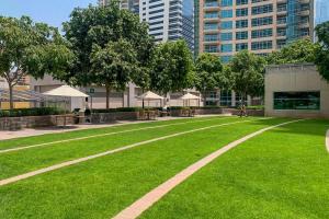 a park with green grass and trees and buildings at Frank Porter - Blakely Tower in Dubai