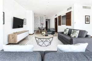 sala de estar con 2 sofás y TV en Frank Porter - Marsa Plaza en Dubái