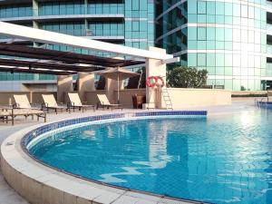 a swimming pool with chairs and a building at Frank Porter - Marsa Plaza in Dubai