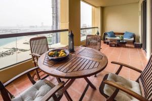 a wooden table with a bowl of fruit on a balcony at Frank Porter - Sadaf 6 in Dubai