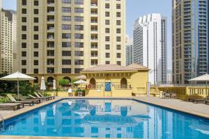 a large swimming pool in a city with tall buildings at Frank Porter - Sadaf 6 in Dubai