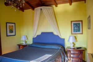 a bedroom with a blue bed with two night stands at Villa Belvedere in Pieve Fosciana