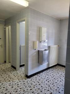 a bathroom with a sink and a tiled wall at Casa Mia Goms in Reckingen - Gluringen