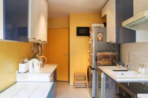 a kitchen with yellow walls and a sink and a refrigerator at A large 104 m family nest in Paris 15th in Paris