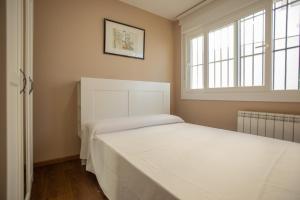 Un dormitorio con dos camas y una ventana. en BAIONA PRIMERA LINEA PLAYA 6 HUESPED CON GARAJE, en Baiona