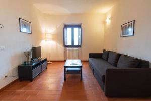 a living room with a couch and a tv at Borgo Gatteraia in Volterra