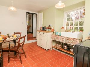 een keuken met een tafel en een wastafel bij Blackbird Cottage in Bideford