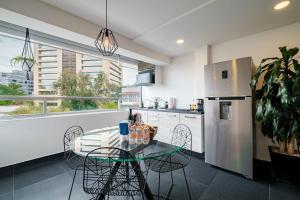 a kitchen with a table and chairs and a refrigerator at Lincoln Square Polanco by RentinBA in Mexico City