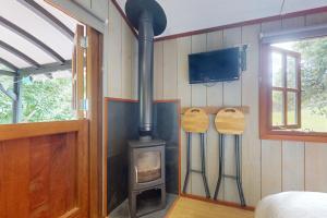 a wood stove in a room with a tv at The Woodmans Hut Minehead in Minehead