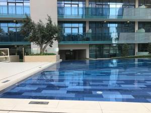 a building with a swimming pool in front of a building at Frank Porter - Merano Tower in Dubai