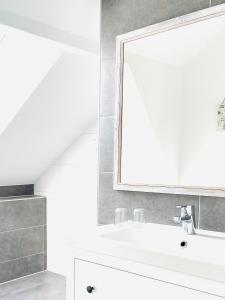 a bathroom with a white sink and a mirror at Gästehaus Teerlings Hafen in Borkum