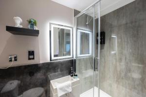 ein Bad mit einer Glasdusche und einem WC in der Unterkunft Charming Brighton Studio Flat in Brighton & Hove