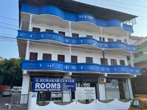 a building with blue balconies on top of it at KRK ROOMS Kottarakara in Kottārakara