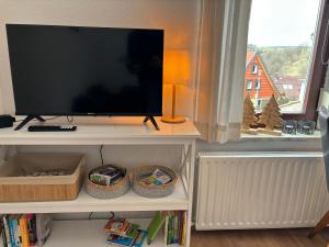 a flat screen tv sitting on a shelf next to a window at Ferienwohnung Daisy in Sankt Andreasberg
