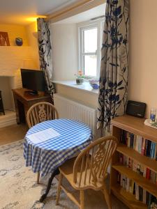 d'un salon avec une table, des chaises et une fenêtre. dans l'établissement The Barn @ Bishops Lydeard, à Taunton