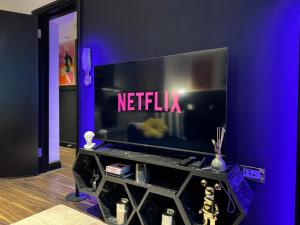 einen TV mit dem Netflix-Schild an der Wand in der Unterkunft Charming Brighton Studio Flat in Brighton & Hove