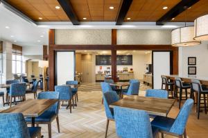 un restaurante con mesas de madera y sillas azules en Hampton Inn & Suites San Juan, en San Juan