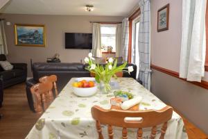 ein Wohnzimmer mit einem Tisch und einer Obstschale in der Unterkunft Birch Cottage in Blairmore + 14 Fotos