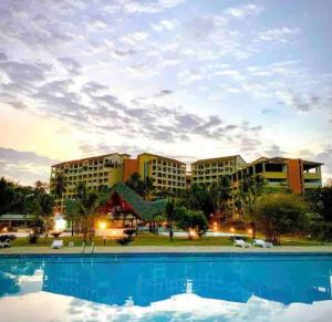 a resort with a large swimming pool in front of a building at Bahari Studio Beach Front Apartment. in Diani Beach