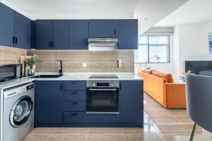 a kitchen with blue cabinets and a dishwasher at Frank Porter - Yacht Bay in Dubai