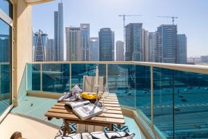 a table on a balcony with a view of the city at Frank Porter - Yacht Bay in Dubai