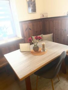 a wooden table with a vase of flowers on it at Ute Urbaner in Irschen