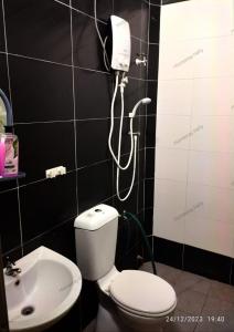 a bathroom with a white toilet and a shower at Homestay Hafiy Manjung Lekir Sitiawan in Lekir