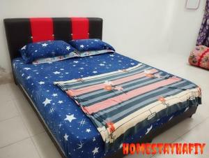 a bed with an american flag blanket and pillows at Homestay Hafiy Manjung Lekir Sitiawan 