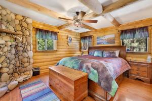 a log cabin bedroom with a bed and a stone wall at Fox Lodge Big Bear-Indoor Pool-Hot Tub-Games-Luxury Retreat in Big Bear City +68 photos