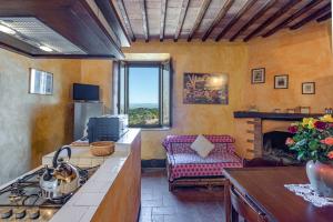 a kitchen with a stove and a couch in a room at La Palazzina in Murlo