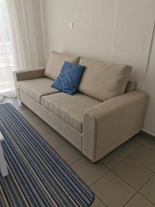 a couch in a living room with a blue pillow at Nostalgia apts in Limassol